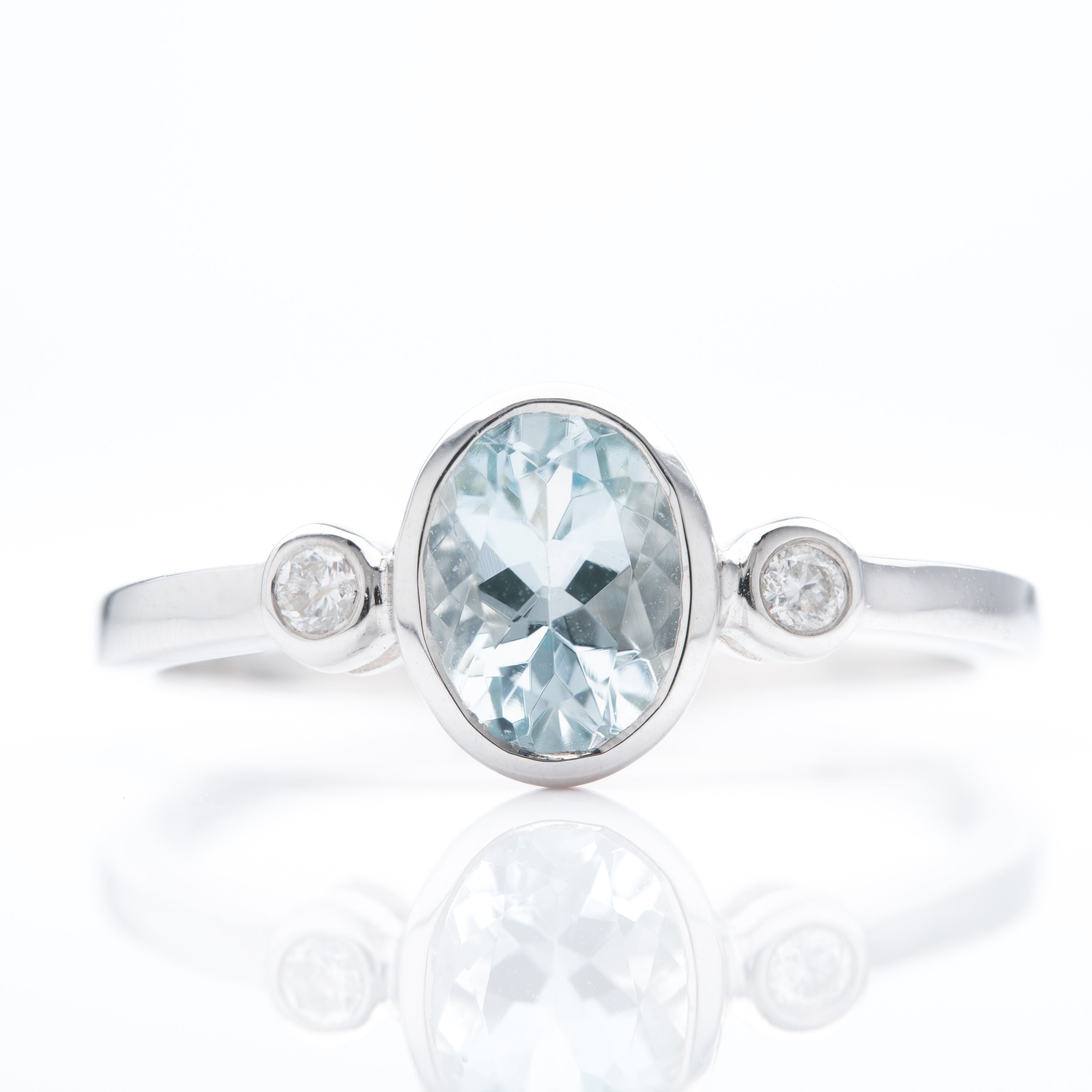 9ct White Gold Oval Cut Aquamarine & Round Brilliant Cut Diamond Rubover Set Trilogy Ring