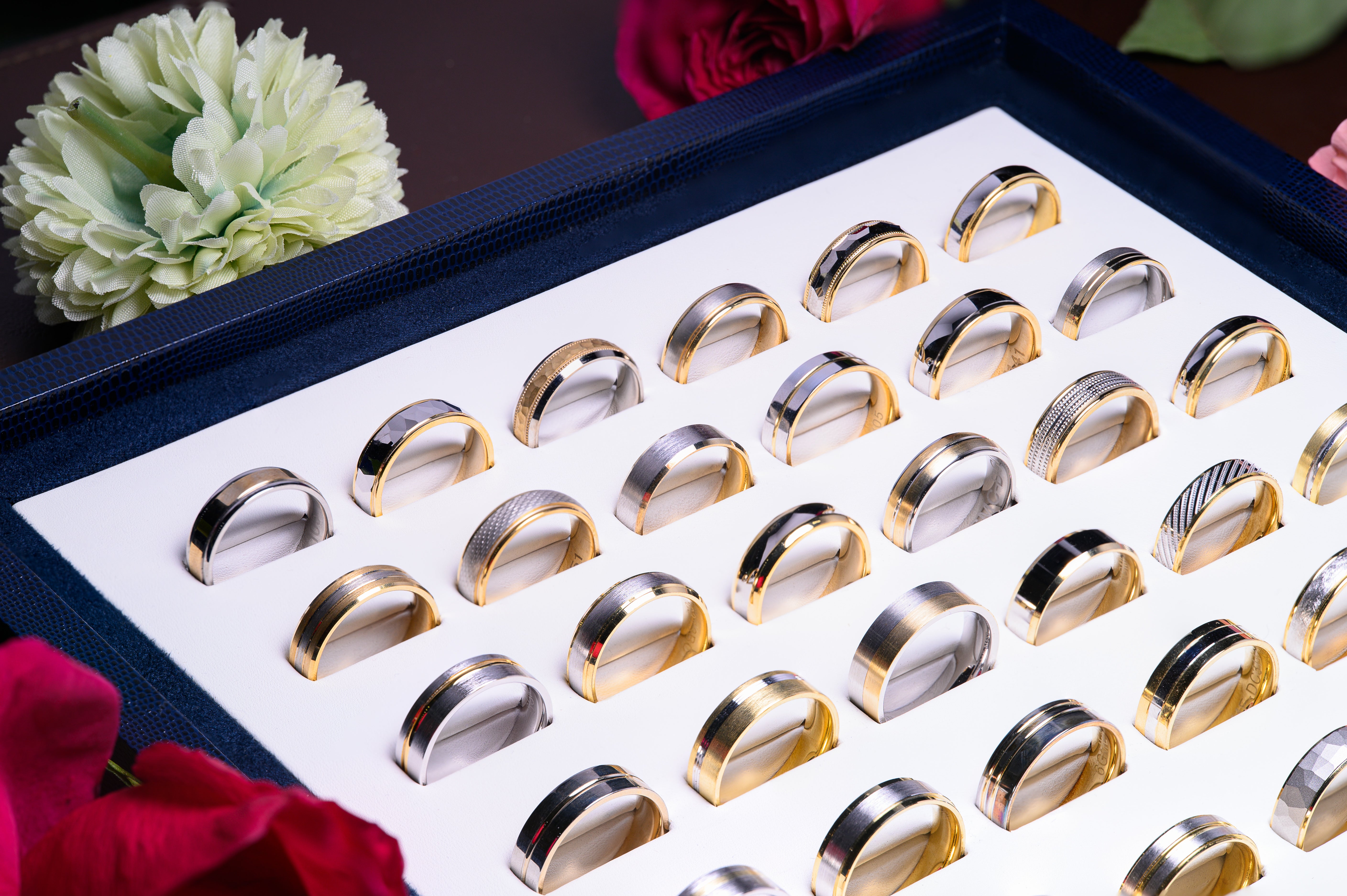 A display of sample metal wedding bands in different styles and textures