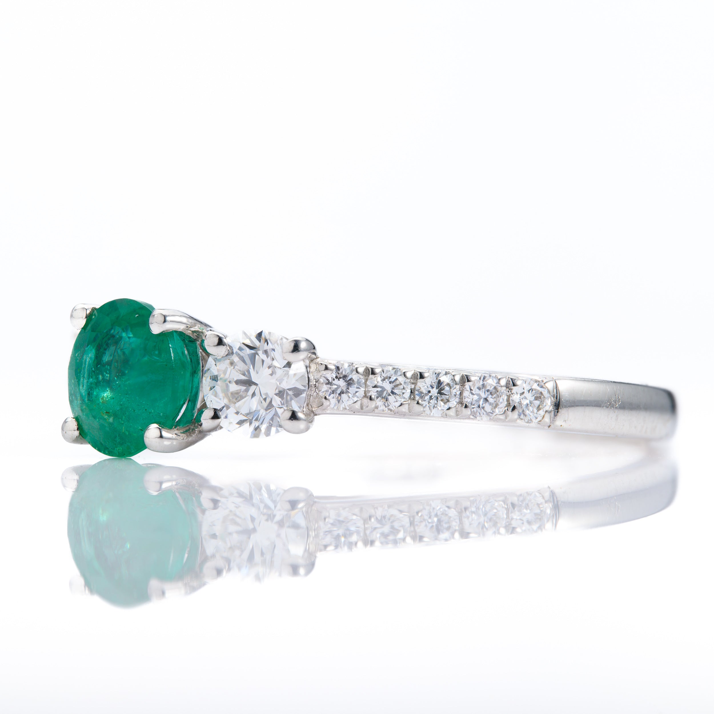Platinum Round Cut Emerald & Round Brilliant Cut Diamond Trilogy Ring with Diamond Shoulders
