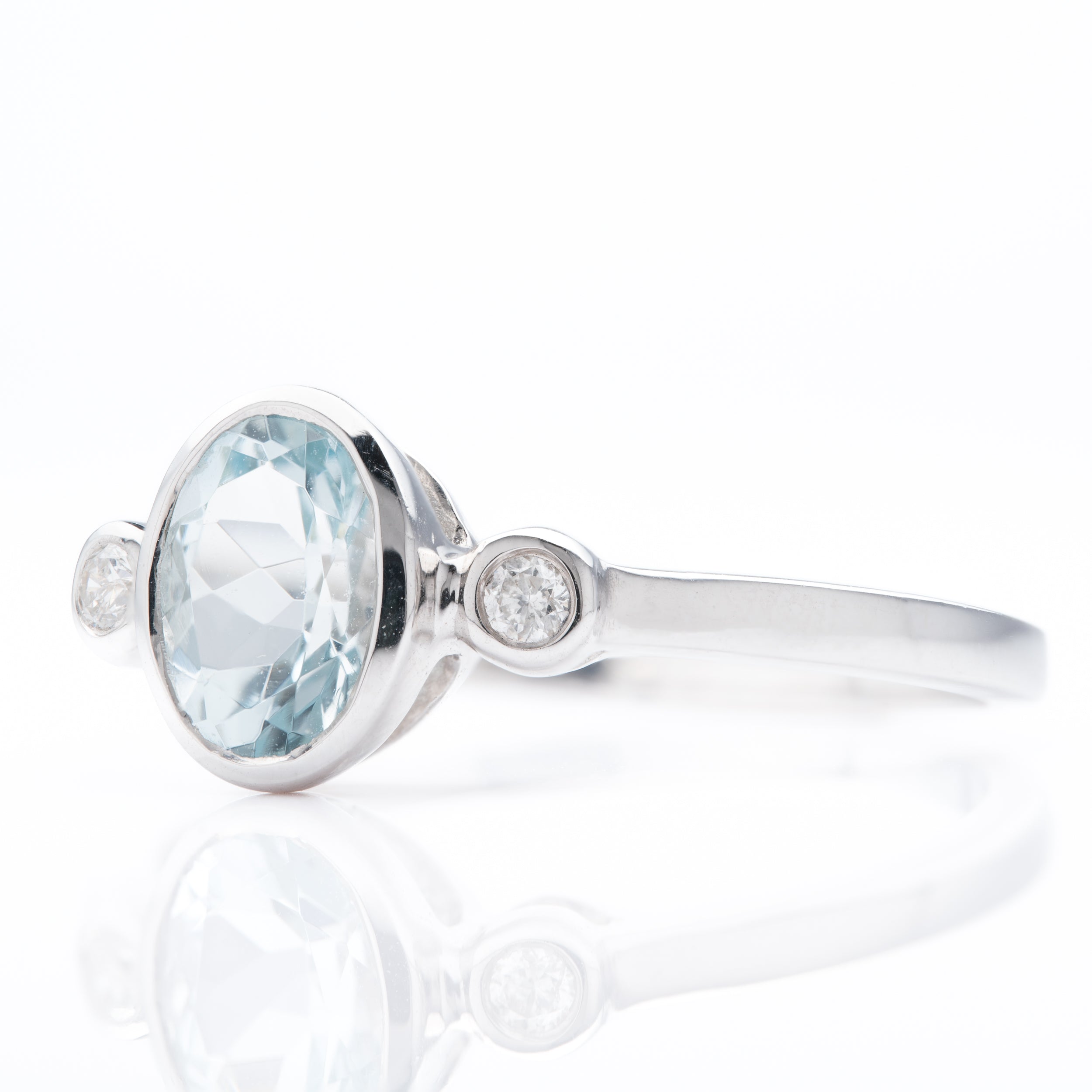 9ct White Gold Oval Cut Aquamarine & Round Brilliant Cut Diamond Rubover Set Trilogy Ring